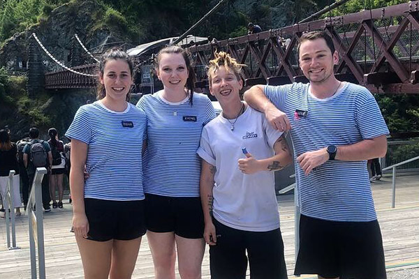 Group of four young people standing in front of AJ Hackett Bungy at Kawarau Bridge